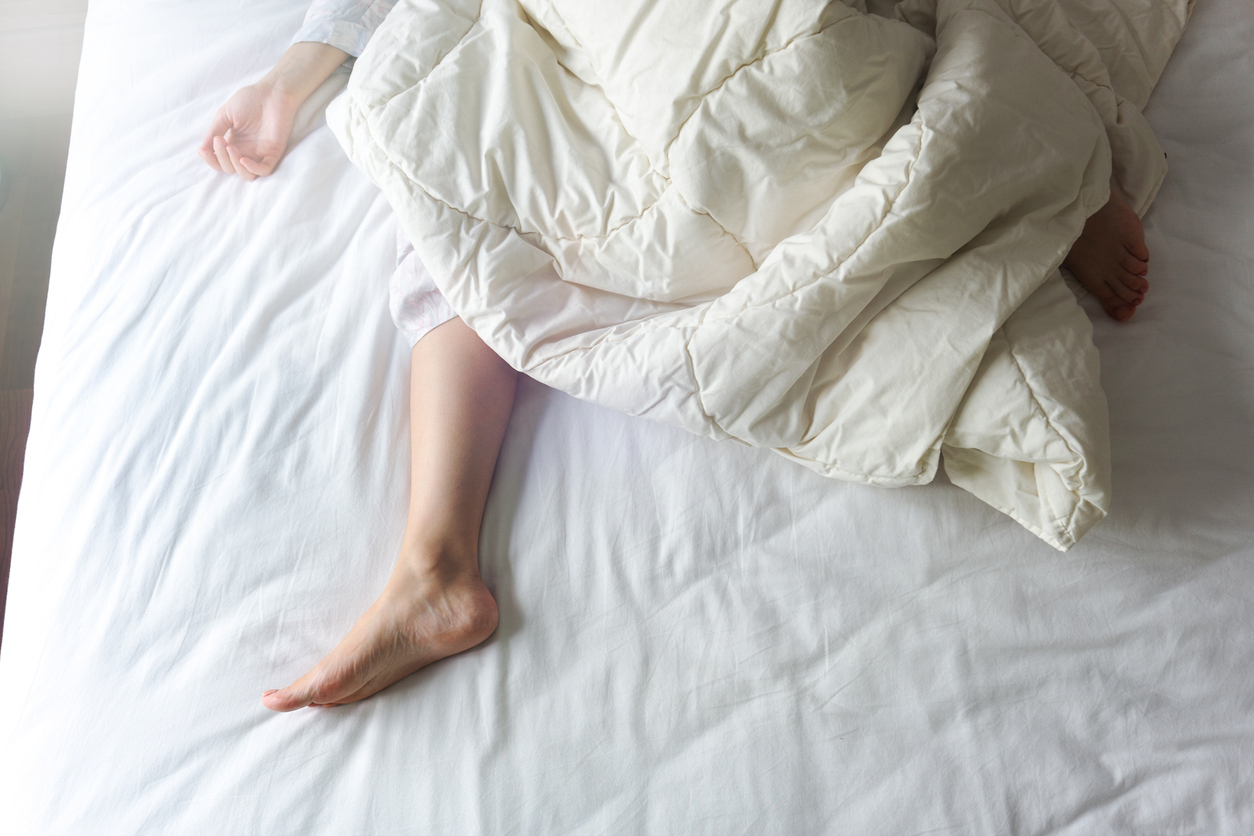 donna nel letto con piede fuori dalla coperta